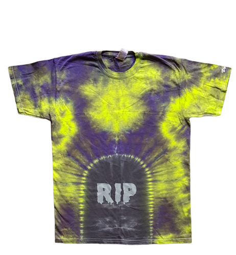 Halloween Tombstone RIP design tie dye shirt. The overall colour of the shirt is green & purple with a grave design at the bottom centre with RIP added in creepy silver writing.