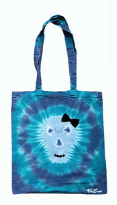 Halloween Skull design tie dye tote bag. Overall colour of the bag is Blue and Green in a circle pattern with a grey skull with black bow, eyes, nose and mouth
