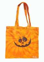 Load image into Gallery viewer, Halloween Smiling Pumpkin design tie dye tote bag. Overall colour of the bag is various shades of orange in swirl pattern with black Smiling Pumpkin